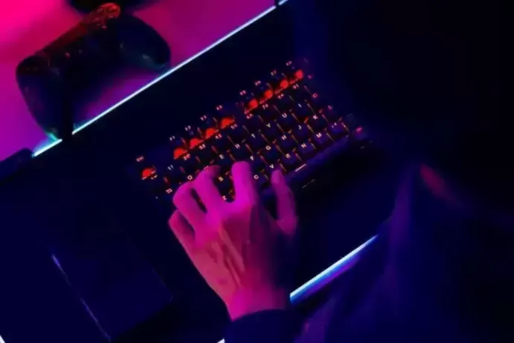 vista de cima de uma pessoa utilizando um teclado mecânico retroiluminado