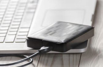 Um Hd externo conectado por USB em cima de um notebook.