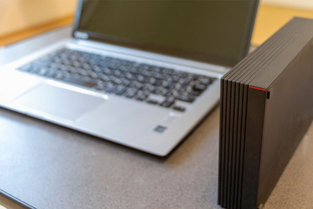 Um HD externo ao lado de um notebook. 