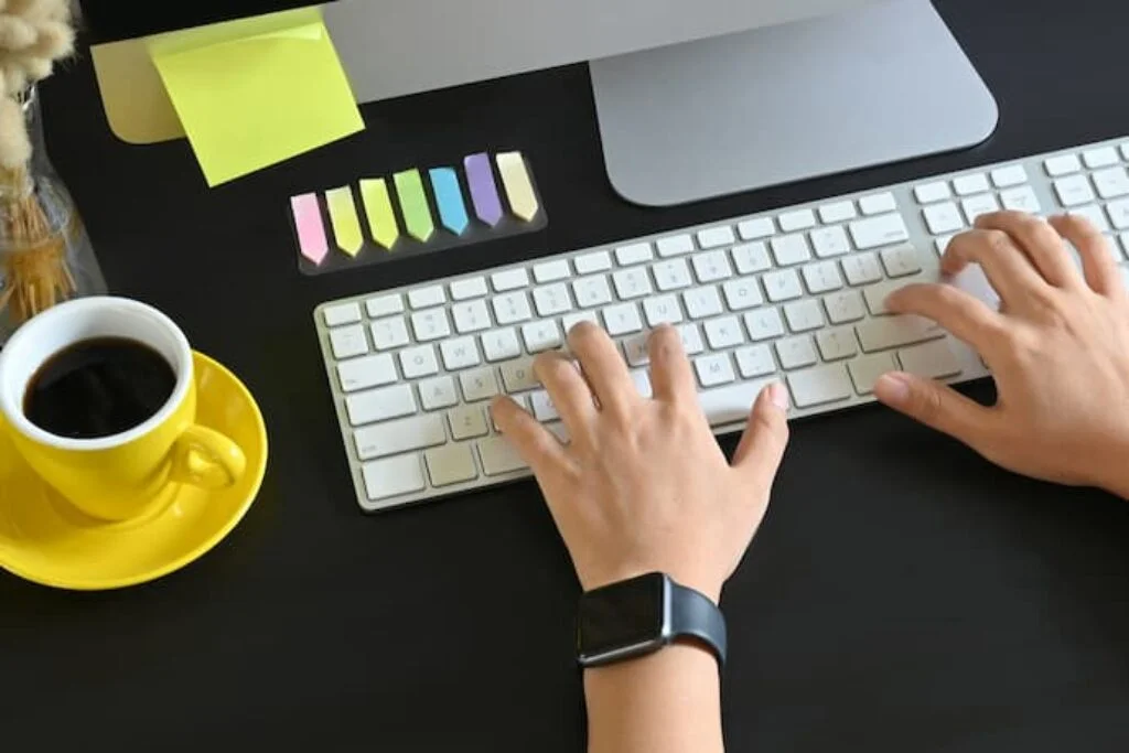 foto de homem usando teclado branco sobre uma mesa