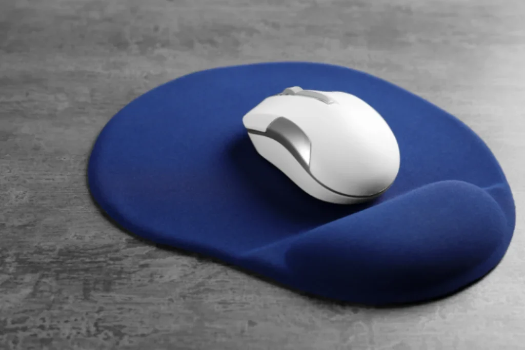 Um mouse pad simples de cor azul com um mouse branco sem fio.