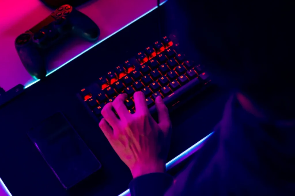 Um mouse pad gamer com um teclado gamer e um controle de video game.