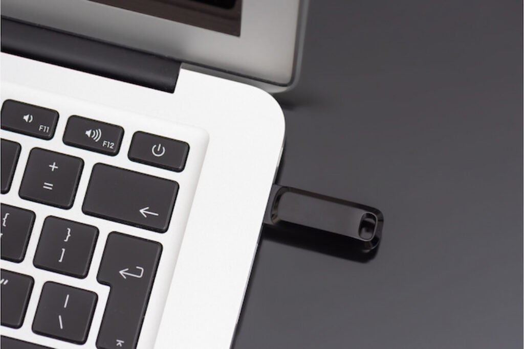 Um pen drive plugado em um notebook.