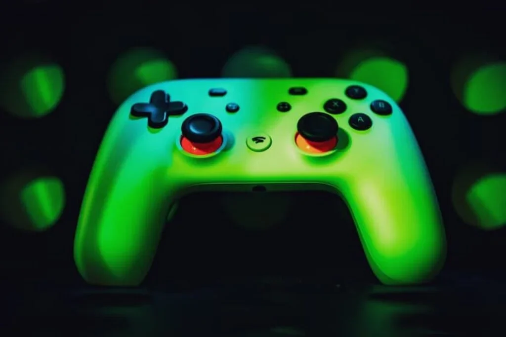 Controle verde com analógicos em laranja.