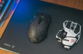 Mouse preto e mouse branco sobre uma mesa.