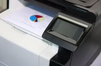 Impressora multifuncional sobre uma mesa.