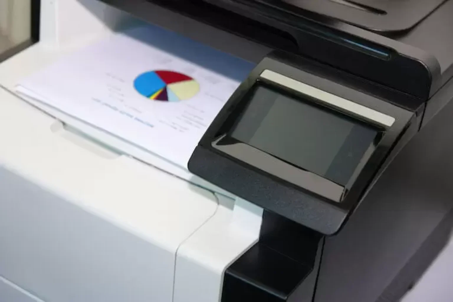Impressora multifuncional sobre uma mesa.