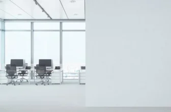 Uma sala de escritório com duas cadeiras e uma mesa ao fundo.