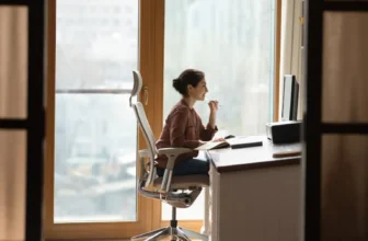 Mulher sentada em cadeira ergonômica para coluna.